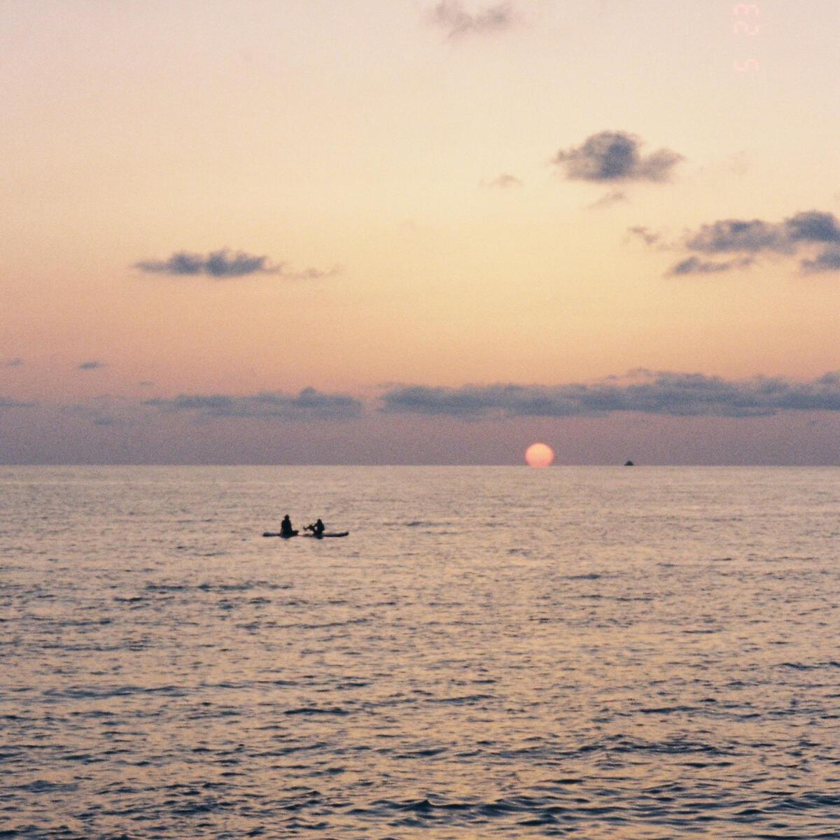 Sunset over the Black Sea with two kayakers silhouetted against the glowing horizon