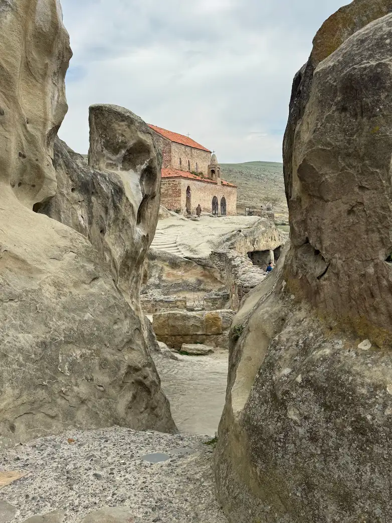A stone church seen through the rock passages of Uplistsikhe